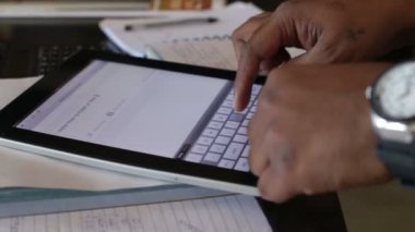 adam kanepede otururken tablete yazma