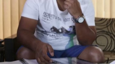 adam kanepede otururken tablete yazma