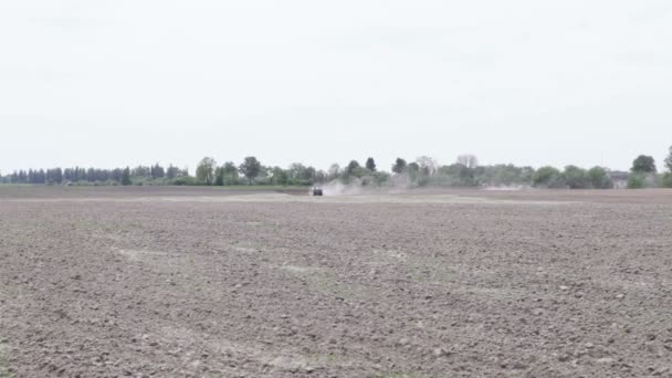 Tracteur labourant le champ de charrue de terre noire — Video