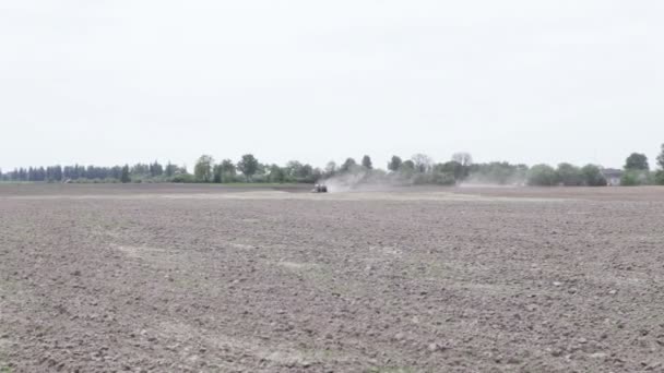 Tractor arando el campo de arado de tierra negra — Vídeo de stock