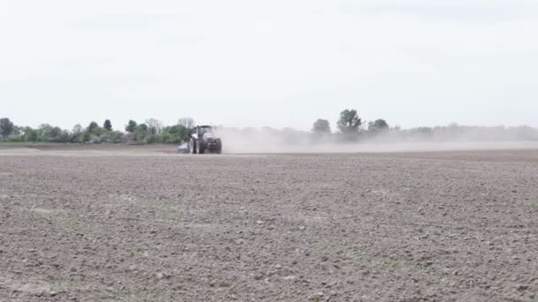 Tractor arando el campo de arado de tierra negra — Vídeo de stock