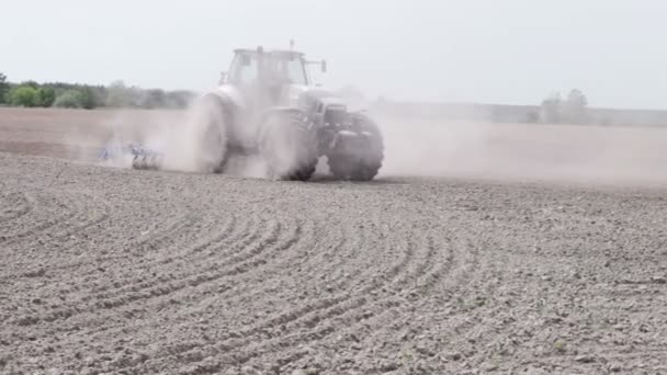 Traktor szántás a fekete föld szántani a mező — Stock videók