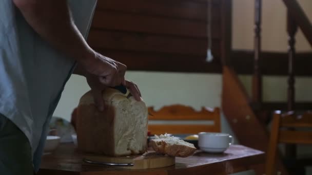 El hombre corta el pan blanco — Vídeos de Stock