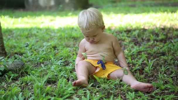 Маленький хлопчик грає у дворі — стокове відео