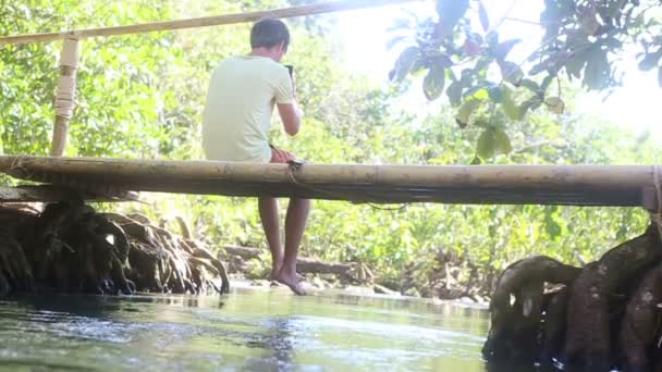 Köprü üzerinde oturan adam — Stok video