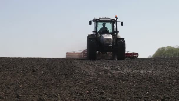 Traktor pflügt schwarzes Feld — Stockvideo