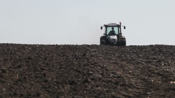 Tractor arando campo negro — Vídeo de stock