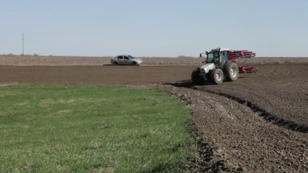 Трактор на поле весной — стоковое видео