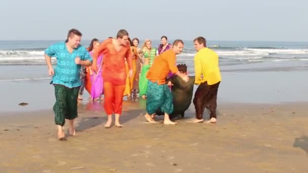 Männer zerren Mann an Strand — Stockvideo