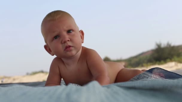 Baby kijken rond naar strand — Stockvideo