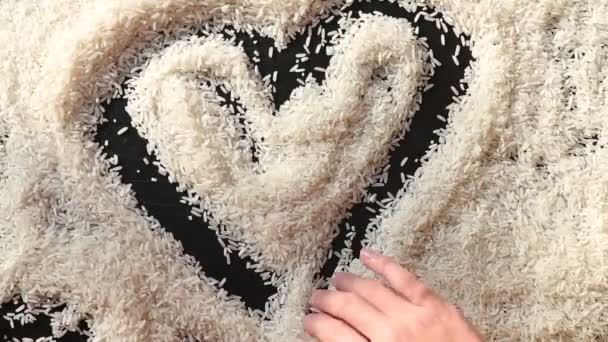 Man hand draw heart on surface of rice — Stock Video