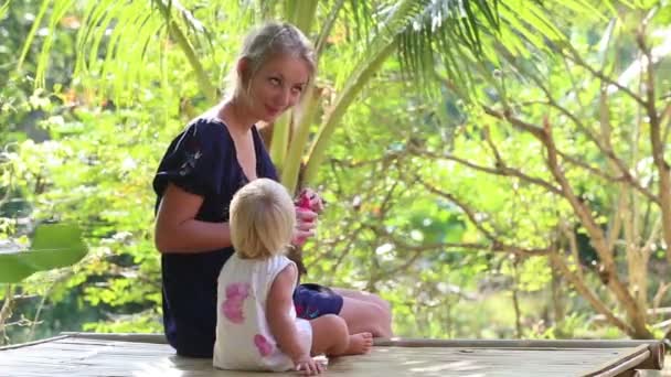 Mãe soprando bolhas para a filha — Vídeo de Stock