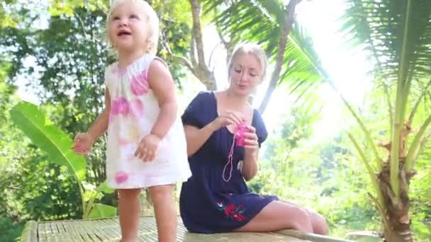 Mother blowing bubbles for daughter — Stock Video