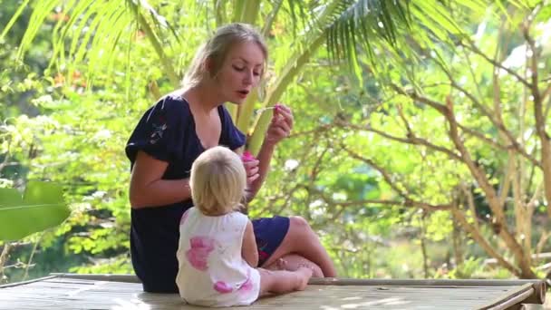 Madre soplando burbujas para hija — Vídeos de Stock