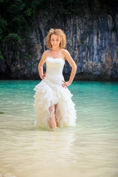 Blonde bride stand in sea water — Stock Photo, Image