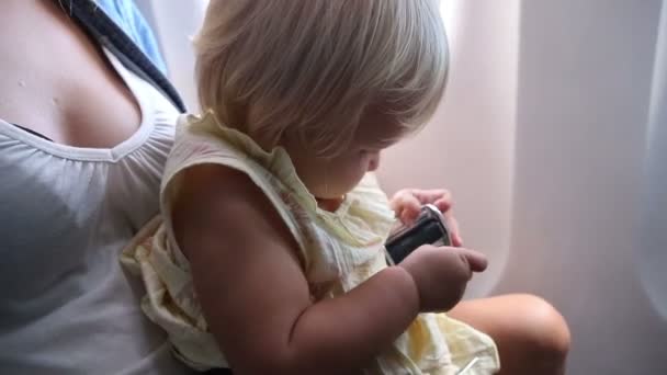 Маленькая девочка пристегивает пояс в самолете — стоковое видео