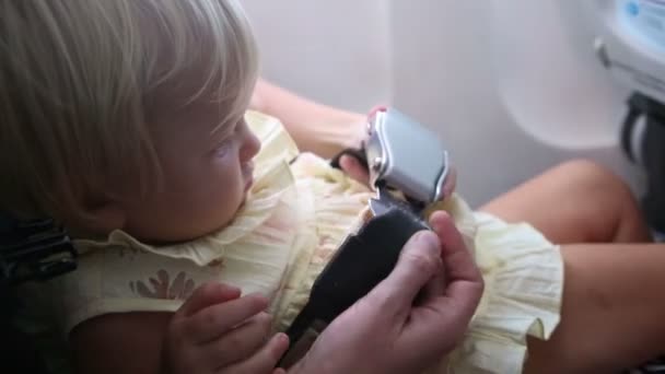 Мати застібає дитину в літаку — стокове відео