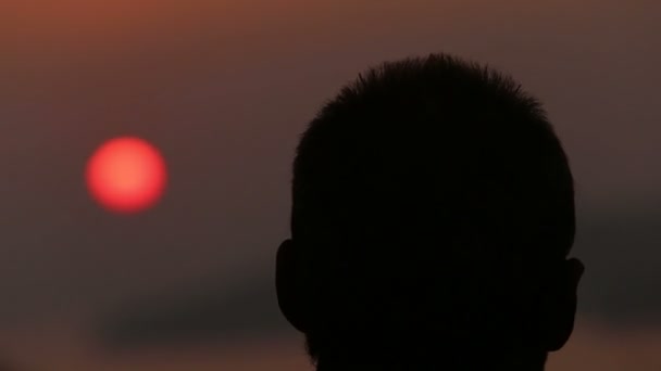Man bewondert zonsondergang over zee — Stockvideo