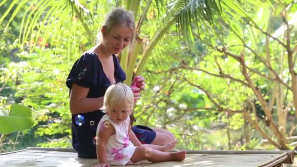 Madre soplando burbujas para hija — Vídeos de Stock