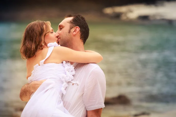 Sposo bacio la sua sposa sulla spiaggia — Foto Stock