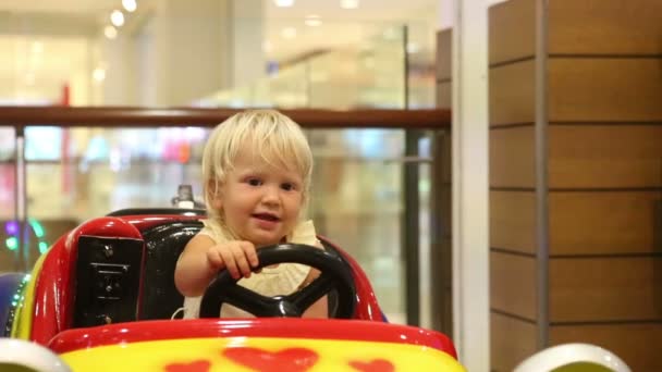 Маленька дівчинка в іграшковій машині — стокове відео