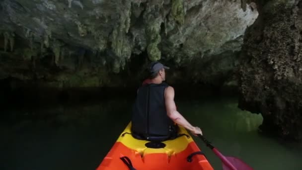 Muž veslování Kajak v jeskyni — Stock video