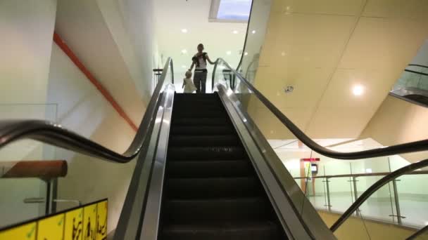 Madre e hija pequeña en escaleras mecánicas — Vídeos de Stock