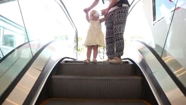 Kind und Mutter bewegen sich auf Rolltreppe — Stockvideo