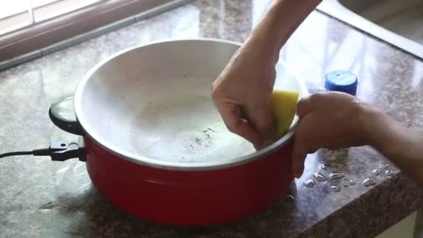 Чоловік чистить електричну сковороду — стокове відео