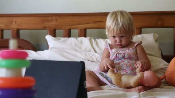 Девушка с игрушками смотрит мультики — стоковое видео