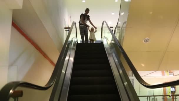 Madre e hija pequeña en escaleras mecánicas — Vídeos de Stock