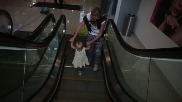 Kind und Mutter bewegen sich auf Rolltreppe — Stockvideo