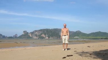 Yaşlı adam sahilde yoga yaparken