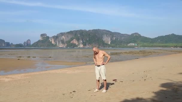 Viejo haciendo yoga en la playa — Vídeo de stock