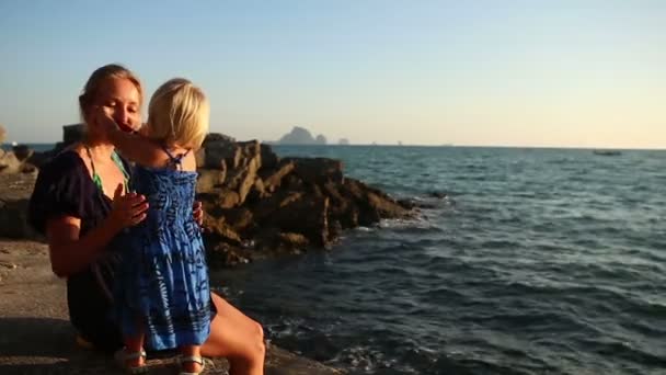 Pieni tyttö laittaa aurinkolasit äidille — kuvapankkivideo