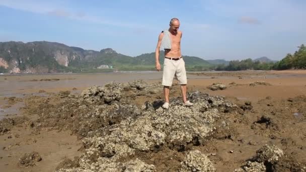 Oude man lopen op strand — Stockvideo