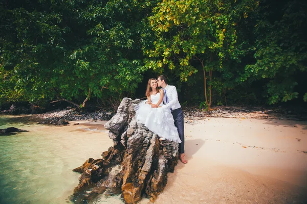 Mariée et marié sur le rocher à la plage — Photo