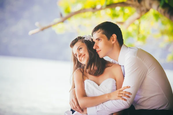 Sposa e sposo sulla roccia in spiaggia — Foto Stock