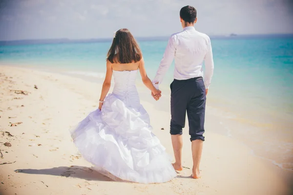 Bride and groom on tropical beach — Stock Photo, Image