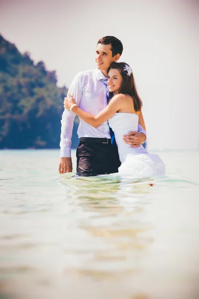 Bride and groom in tropic sea — Stock Photo, Image