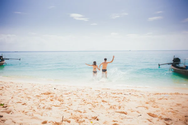 Young man and woman on sea beach — Stock Photo, Image