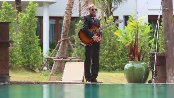 Guitariste barbu en costume près de la piscine — Video