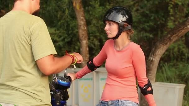 Девушка на скутере разговаривает с мужчиной — стоковое видео