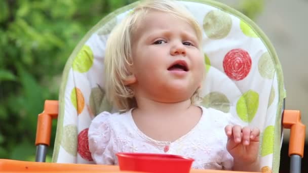 Маленькая девочка ест манго — стоковое видео