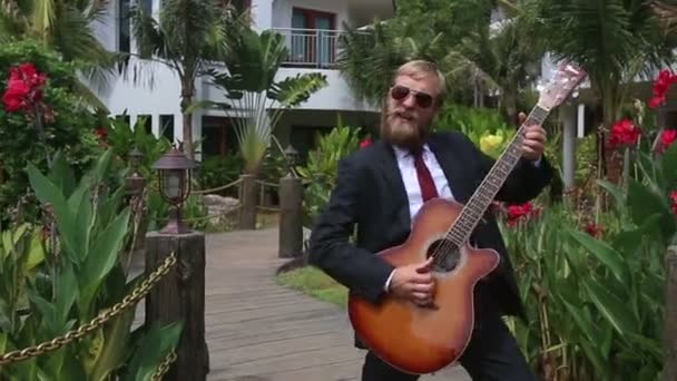 Hombre de traje y gafas tocando la guitarra — Vídeos de Stock