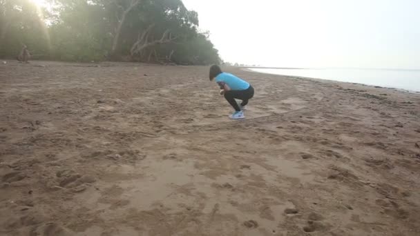 Meisje doet van de ochtend oefeningen op strand — Stockvideo