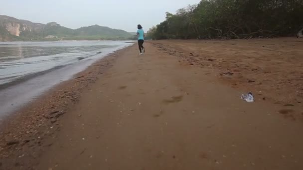 Menina pulando ao longo da praia — Vídeo de Stock