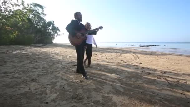 Hombre con guitarra y chica en la playa — Vídeos de Stock