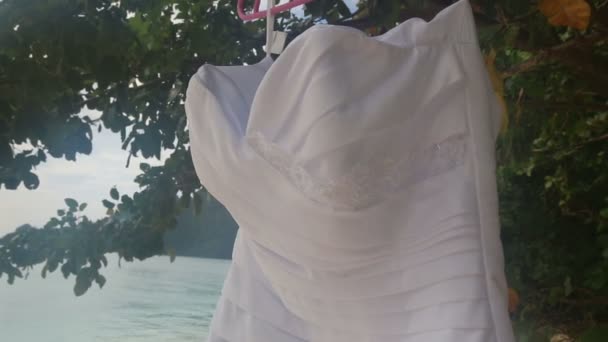 Svatební šaty visí na pláži — Stock video