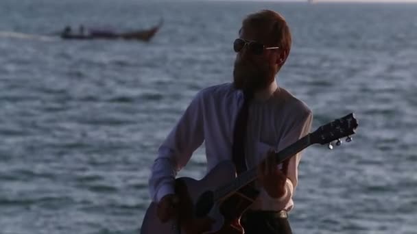 Guitarrista tocando la guitarra en el mar — Vídeos de Stock